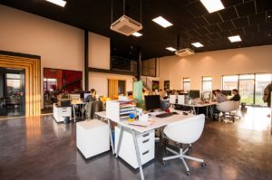 Office with an open floor plan, desks in the center of the room