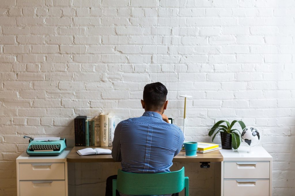 mployee Working, at a Desk With Plants, Books & More