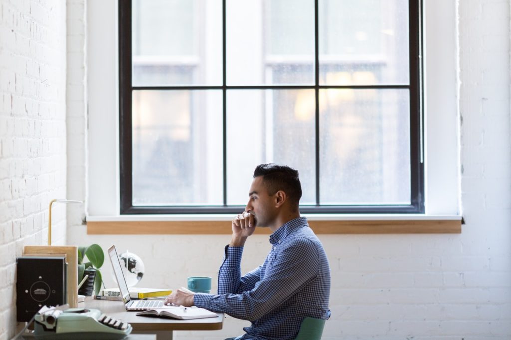 Man Sitting Up Straight in His Chair, Working on Computer